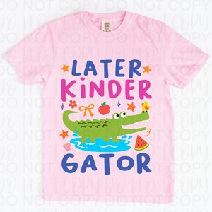 K&ouml;nnte beinhalten: Hellrosa T-Shirt mit dem Schriftzug "LATER KINDER GATOR" in Blau und Pink. Das Design zeigt ein gr&uuml;nes Alligator, einen Apfel, eine Wassermelone und andere farbenfrohe Grafiken.