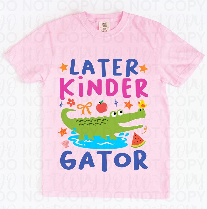 K&ouml;nnte beinhalten: Hellrosa T-Shirt mit dem Schriftzug "LATER KINDER GATOR" in Blau und Pink. Das Design zeigt ein gr&uuml;nes Alligator, einen Apfel, eine Wassermelone und andere farbenfrohe Grafiken.