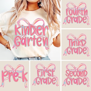 Może przedstawiać: Kremowa koszulka z napisem "Kindergarten" w kolorze różowym, obramowanym na niebiesko, oraz wzorem tęczowej kokardy. Dodatkowe obrazy przedstawiają projekty z napisami "Pre-K", "First Grade", "Second Grade", "Third Grade" i "Fourth Grade".