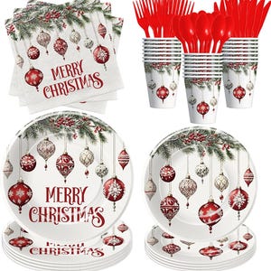 May include: A festive Christmas party set featuring plates, cups, napkins, and cutlery. The white plates and cups are adorned with hanging ornaments and the text "MERRY CHRISTMAS". Red plastic forks, spoons, and knives complete the set.
