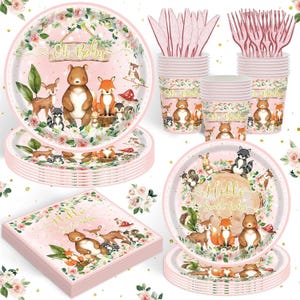 May include: Pink and white baby shower party supplies set. Includes plates, cups, napkins, and cutlery. The plates and cups feature woodland animal illustrations and the text "Oh Baby" and "Hello Sweet Baby".