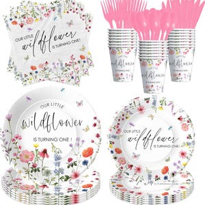May include: A set of white paper plates and cups with a floral design and the text "Our Little Wildflower is Turning One!"  The plates and cups are decorated with butterflies and wildflowers.  The set also includes pink plastic forks and spoons.