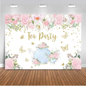 May include: A white backdrop with a blue teapot and teacup decorated with pink flowers and gold glitter. The text "Tea Party" is written in gold glitter on the backdrop. Butterflies are scattered around the teapot and teacup.