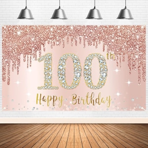 May include: A pink and gold glitter backdrop with the number 100 in gold with rhinestones and the text "Happy Birthday" in gold.