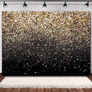 May include: A black and gold glitter backdrop with a gradient effect. The glitter is dense at the top and fades to a black background at the bottom.
