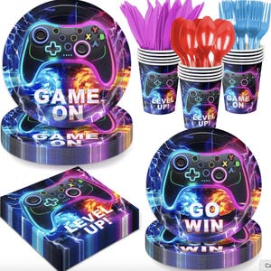 May include: A video game themed party supply set featuring round paper plates, paper cups, and square napkins with a black game controller graphic, lightning patterns, and the text GAME ON, LEVEL UP, and GO WIN, plus purple knives and red spoons.