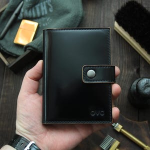 May include: A black leather wallet with a snap closure and the text "OVC" embossed on the front.