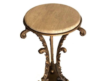 May include: A gold-tone metal side table with a round, off-white marble top and ornate scrollwork details.