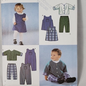 以下が含まれることがあります： サイズXXS、XS、S、M、Lの子供服用のSimplicity 9911型紙封筒。表紙には、ジャンパースカート、パンツ、ボタン付きジャケットのイラストと、完成した服を着た子供たちの写真が掲載されています。