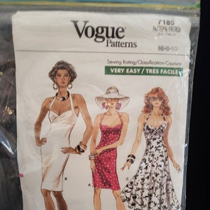 May include: Vogue Patterns sewing pattern for a dress, featuring three different styles: a white dress, a red polka dot dress, and a floral print dress. The pattern is labelled "Very Easy/Tres Facile" and includes sizes 16-8-101.