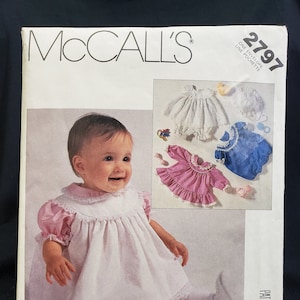 May include: McCall's sewing pattern number 2797 for a baby dress. The pattern includes instructions for making a white dress with pink and blue accents. The pattern is for one envelope.