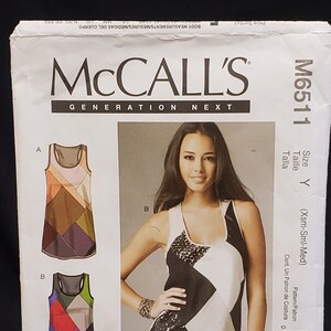 May include: McCall's Generation Next sewing pattern for a sleeveless top. The pattern is for sizes X-Small, Small, and Medium. The pattern includes instructions and diagrams for sewing the top. The pattern is for a top with a geometric design.