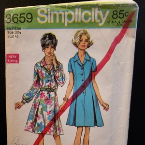 May include: Simplicity sewing pattern number 3659 for a half-size dress. The pattern is for sizes 18 1/2 and has a bust measurement of 41 inches. The pattern shows two models wearing different versions of the dress. One model is wearing a floral print dress and the other is wearing a solid blue dress. The pattern is priced at 85 pence.