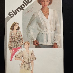 May include: Simplicity sewing pattern number 9871 for a blouse with a V-neckline and long sleeves. The pattern includes three different views, each with a different style of sleeve. The pattern is for sizes 6 & 8, and the price is £2.50.