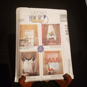 May include: McCall's Home Dec sewing pattern number 2788 for window treatments. The pattern includes four different designs: a swag and handkerchief jabot, swagged triangle panels, a sheer balloon valance, and a topper with noids and glands. The pattern is in a-sec, meaning it can be completed in two hours or less.