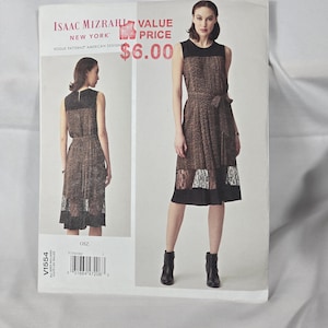 May include: A sewing pattern envelope for an Isaac Mizrahi New York Vogue Patterns dress. The front shows a sleeveless dress with a black bodice, a brown and black animal print skirt, a waist tie, and a black lace hem. Text includes V1554 and OSZ.