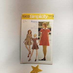 Könnte beinhalten: Simplicity Schnittmuster Nummer 5903 für ein Kleid. Das Schnittmuster enthält Anweisungen zum Nähen des Kleides. Das Schnittmuster ist für Größe 10, Brustumfang 82 cm.