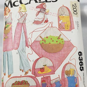 May include: McCall's sewing pattern envelope with illustrations of aprons, kitchen accessories, and a woman in a headscarf. The envelope has a red and white checkered pattern and the text "McCall's" and "6365".