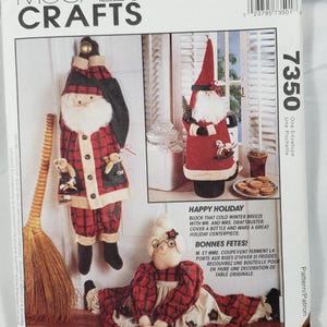 May include: McCall's Crafts pattern for festive holiday decorations. The image shows a pattern for Mr. and Mrs. Draftbuster bottle covers and a holiday centerpiece. The pattern includes instructions for making festive items.