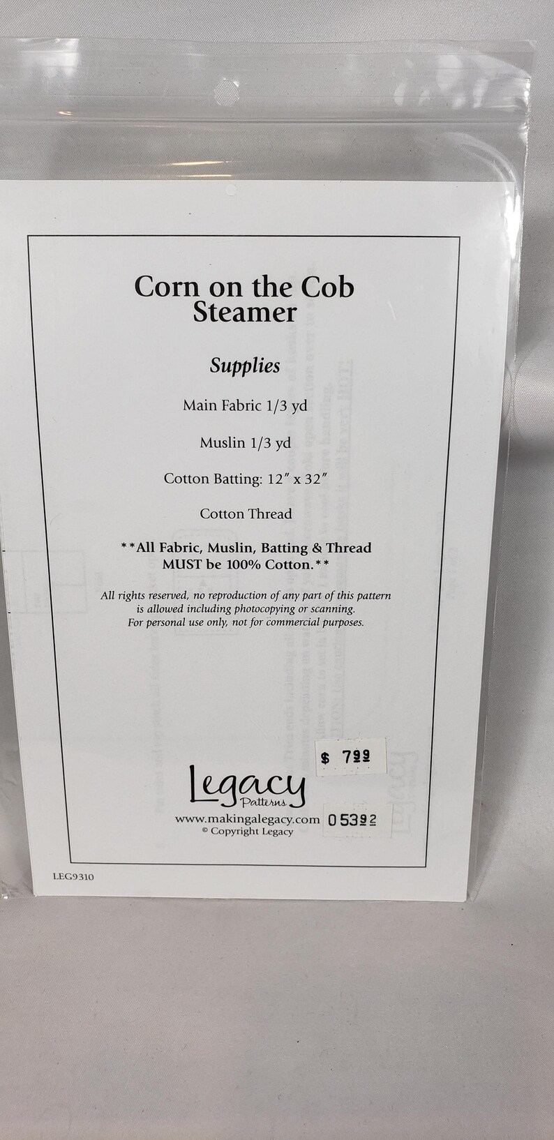 May include: A sewing pattern for a Corn on the Cob Steamer, including fabric, muslin, batting, and thread. The cotton batting measures 30.48 cm x 81.28 cm. The text "Legacy Patterns" is visible on the package.
