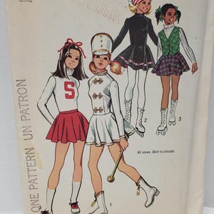 May include: Vintage Simplicity sewing pattern number 5111 for a girl's costume. The pattern includes three different looks: a cheerleader, a drum majorette, and a skater. The pattern is for size 8 and costs £1.00.