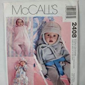 May include: McCall's 2408 sewing pattern envelope for baby wear. The front features three images of infants in hooded jumpsuits, including a pink one, a patterned one, and a gray one. Text includes McCall's, 2408, and Baby Wear.