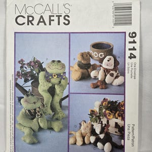May include: McCall's Crafts sewing pattern featuring stuffed animal designs, including a frog, dog, and cat. The pattern includes instructions for creating various plush toys with different accessories. The pattern is by Cynthia Rose.