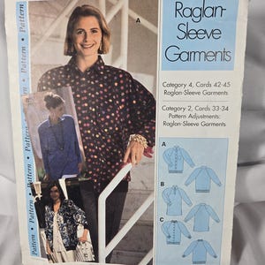 May include: A sewing pattern envelope titled Raglan Sleeve Garments featuring illustrations and photographs of three different shirt styles labeled A, B, and C. The envelope includes text detailing category numbers and pattern adjustment information.