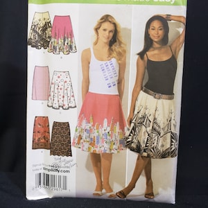 May include: A sewing pattern for six different skirts. The pattern is for sizes 12, 14, 16, 18, and 20. The pattern is from Simplicity and is labeled "6 made easy".
