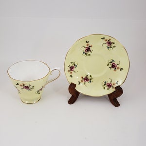 Royal Grafton light delicate yellow tea cup and saucer with pink flower sprays around the cup and saucer