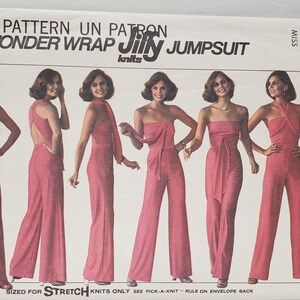 以下が含まれることがあります： ヴィンテージのSimplicityソーイングパターン、Wonder Wrap Jiffy Jumpsuit。ピンク色の生地でいくつかのジャンプスーツスタイルが特徴です。パターンエンベロープには「ONE PATTERN UN PATRON WONDER WRAP JIFFY JUMPSUIT」というテキストが含まれています。