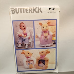 May include: A vintage sewing pattern for making a kangaroo stuffed animal with a baby kangaroo inside. The pattern is from Butterick and is size 4162. The pattern also includes instructions for making a baby bib and a picture frame.