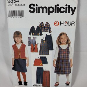 Könnte beinhalten: Ein Simplicity Schnittmusterumschlag 9854 für Kinderkleidung in Größe A 2,3,4,5,6,6X. Die Vorderseite zeigt Illustrationen von Westen, Röcken, Kleidern und Hosen sowie Fotos von Kindern, die eine Weste, einen Rock und ein kariertes Trägerkleid tragen.