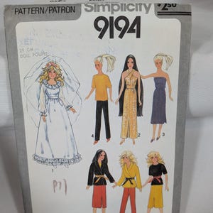 May include: A Simplicity 9194 sewing pattern envelope for 29 cm dolls. The front features illustrations of various doll outfits, including a wedding dress with a veil, pants, skirts, and tops. The text includes the brand name, pattern number 9194, and doll size.