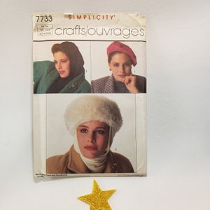 May include: Simplicity crafts pattern 7733 featuring images of women wearing a hood, beret, and fur hat. The pattern includes instructions for making a hood and headband. The pattern is one size.