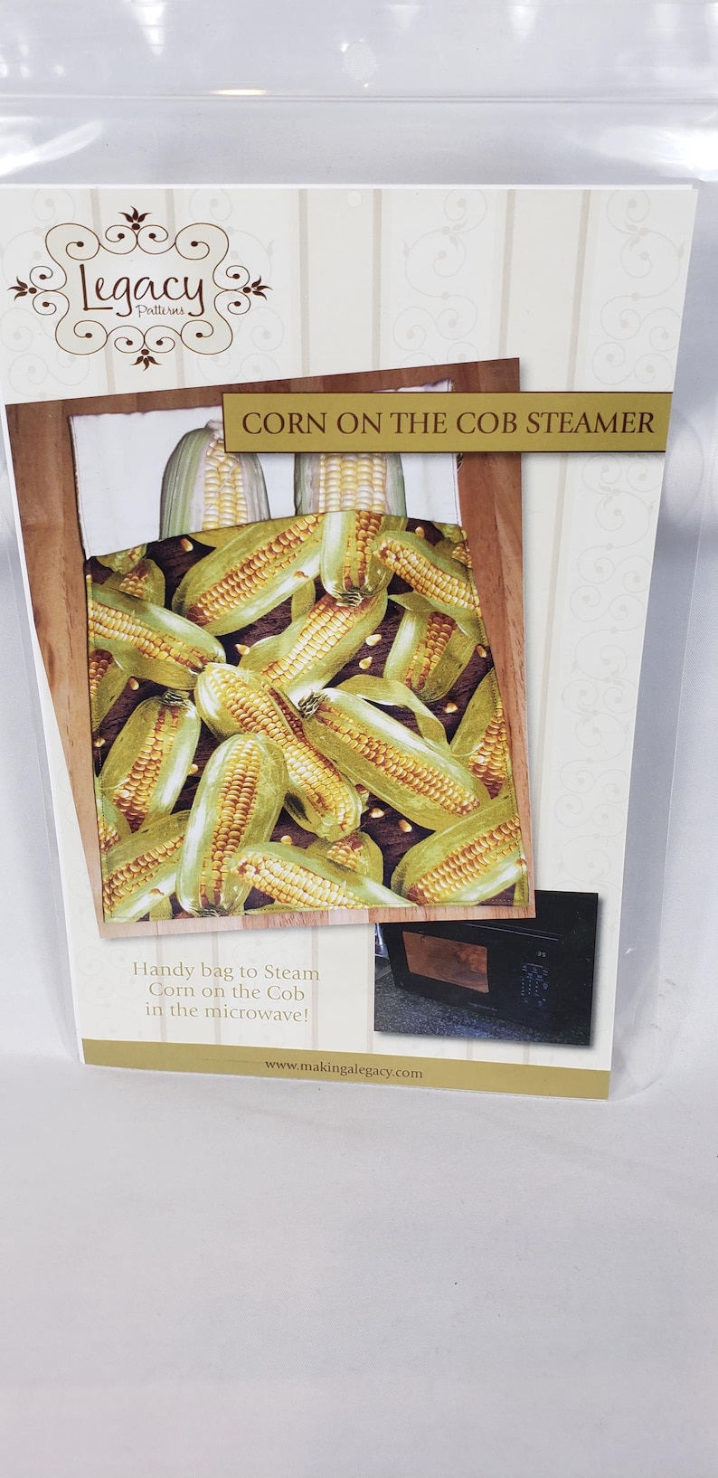 May include: A package for a corn on the cob steamer. The image shows cooked corn on the cob. The text reads "CORN ON THE COB STEAMER" and "Handy bag to Steam Corn on the Cob in the microwave!" with a website address.