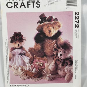 Puede incluir: Patrón de costura McCall's Crafts con osos de peluche. La imagen muestra un sobre de patrón con ilustraciones de osos de peluche con sombreros, vestidos y accesorios. El número de patrón es 2272.
