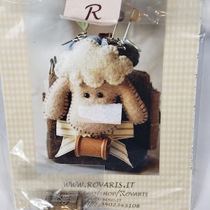 May include: A Rovaris craft kit in a clear plastic package. The kit features a felt sheep pincushion with a brown spool of thread and a small metal charm. The package has the Rovaris logo and website address.