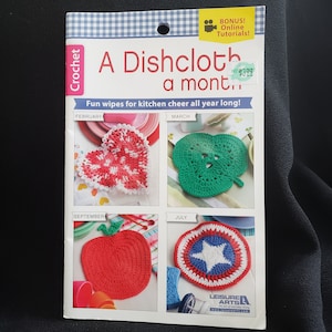 May include: A crochet pattern booklet featuring a dishcloth design for each month of the year. The designs include a heart, a shamrock, an apple, and a star. The booklet cover is red, white, and blue with the title "A Dishcloth a Month!" and the text "Fun wipes for kitchen cheer all year long!"