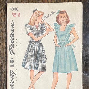 Peut inclure: Un patron Simplicity vintage présentant deux modèles de robes. L'une est à carreaux vichy avec des volants, l'autre est bleu clair uni avec des poches. Le patron comprend la taille 12 et un tour de poitrine de 76 cm. Le texte indique "Simplicity's Truly Teen Style."