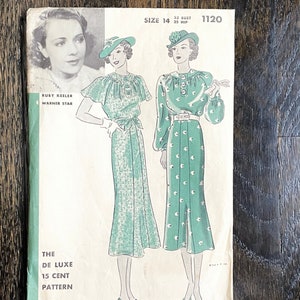 May include: Vintage Hollywood Pattern featuring Ruby Keeler. The pattern shows two illustrations of dresses with matching hats. The cover is green and white with text that reads "THE DE LUXE 15 CENT PATTERN" and "HOLLYWOOD PATTERN".
