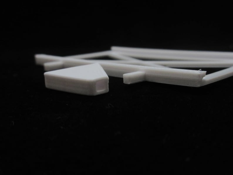 May include: White plastic model train track pieces. The track is curved and straight. The pieces are designed to connect together to create a model train layout.