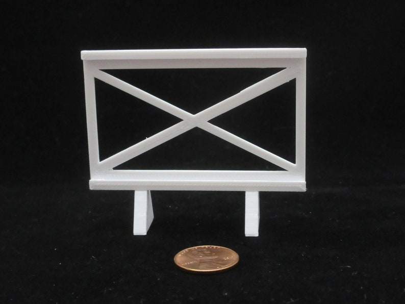 May include: White plastic fence with a criss-cross pattern and two legs. The fence is about the size of a US penny.