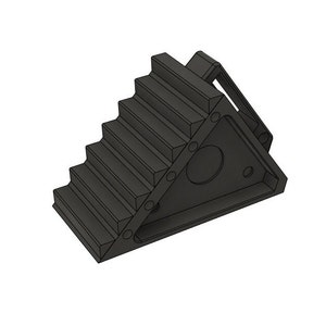 May include: A black wheel chock with a stair-step design. The chock has a triangular base with a circular cutout and several smaller holes. A handle extends from the top.