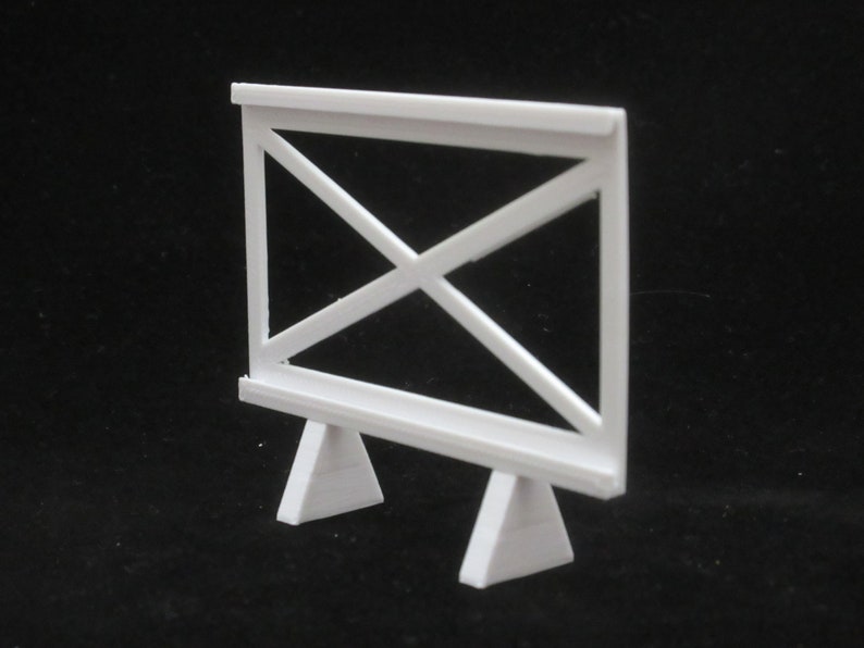 May include: White wooden easel with a simple X-shaped design. The easel has a rectangular frame and two triangular legs.