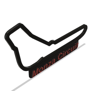 Può includere: Contorno nero del circuito di Monza con il testo "Monza Circuit" in rosso.