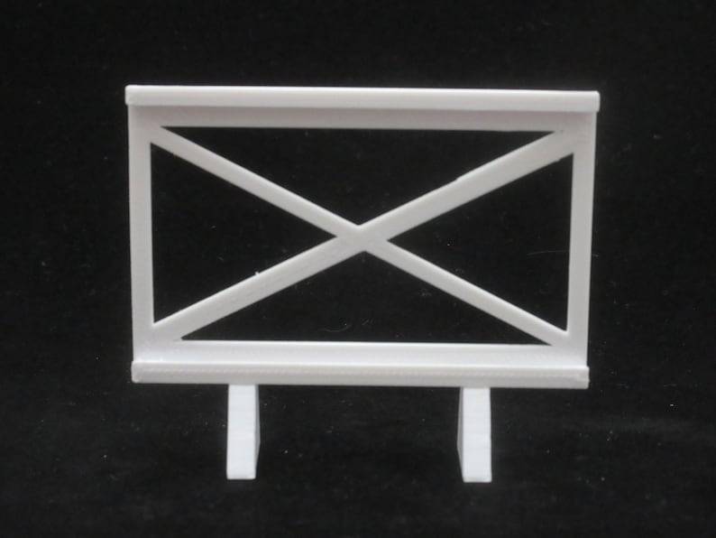 May include: White plastic fence with a criss-cross pattern and two legs. The fence is about 10 inches tall.