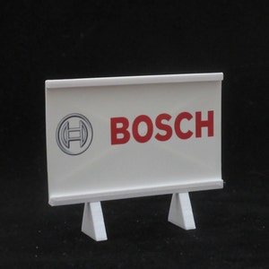 May include: White sign with a red "BOSCH" logo and a gray circle with a stylized "H" inside. The sign is on a white stand with three legs.