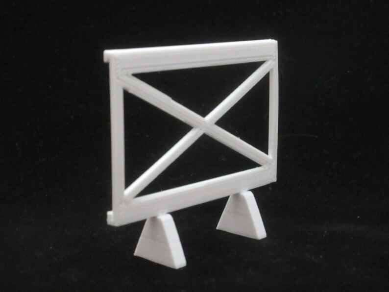 May include: White plastic model of a fence with a criss-cross pattern and two triangular bases.