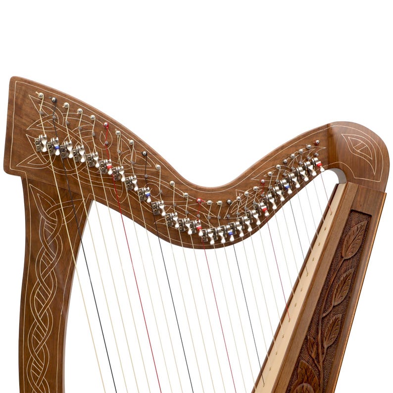 May include: A wooden harp with intricate carvings and strings. The harp features a dark brown finish with detailed Celtic knot and leaf designs. The strings are visible, and the tuning pegs are silver and colored.